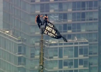 Two climbers atop the Empire State Building antenna in New York City - WABC-TV via AP