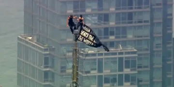 Two climbers atop the Empire State Building antenna in New York City - WABC-TV via AP