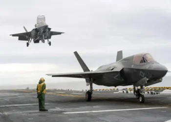 Two F-35B Lightning II stealth fighter aircraft land on the flight deck of the USS America during operational testing in the Pacific Ocean.
