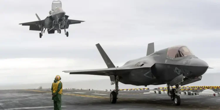 Two F-35B Lightning II stealth fighter aircraft land on the flight deck of the USS America during operational testing in the Pacific Ocean.