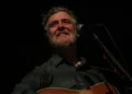 Irish singer-songwriter Glen Hansard performs on stage with an acoustic guitar during a concert at the Palace Theatre in St. Paul, Minnesota.