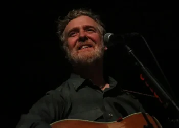 Irish singer-songwriter Glen Hansard performs on stage with an acoustic guitar during a concert at the Palace Theatre in St. Paul, Minnesota.