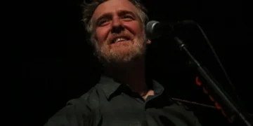 Irish singer-songwriter Glen Hansard performs on stage with an acoustic guitar during a concert at the Palace Theatre in St. Paul, Minnesota.