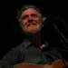 Irish singer-songwriter Glen Hansard performs on stage with an acoustic guitar during a concert at the Palace Theatre in St. Paul, Minnesota.
