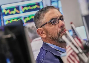 Electronic market boards display mixed global stock index performances and AI shares. - AP Photo/Richard Drew