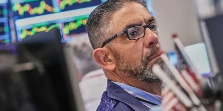 Electronic market boards display mixed global stock index performances and AI shares. - AP Photo/Richard Drew