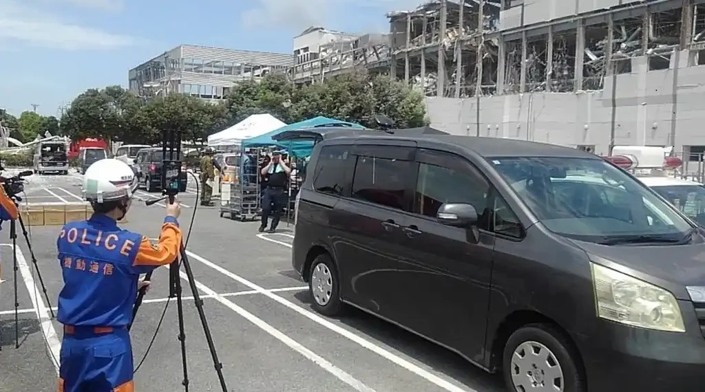 National Police Agency personnel operate emergency communications equipment during the 2026 Kumamoto earthquake response at Aeon Mall Kumamoto in Japan.