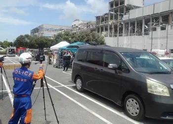 National Police Agency personnel operate emergency communications equipment during the 2026 Kumamoto earthquake response at Aeon Mall Kumamoto in Japan.