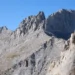 Mountain landscape in Olympus National Park, Greece, showing forested slopes, rocky peaks, and natural scenery beneath a clear sky.