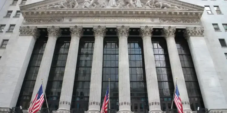 Exterior view of the New York Stock Exchange building on Wall Street in New York City's Financial District, displaying its neoclassical façade and American flags.