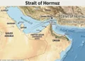 Relief map of the Strait of Hormuz showing Iran, Oman, the United Arab Emirates, the Persian Gulf, the Gulf of Oman, Bandar Abbas, and the international shipping lanes through the strategic waterway.