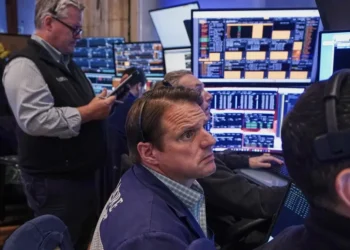 Electronic stock market display showing gains driven by AI-related shares - AP Photo/Richard Drew