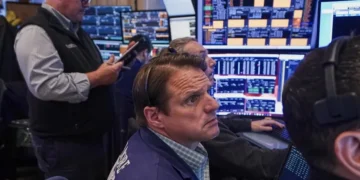 Electronic stock market display showing gains driven by AI-related shares - AP Photo/Richard Drew