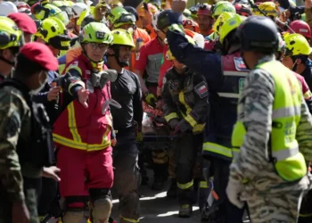 Rescue teams carry survivor from collapsed shopping center in Venezuela. - AP Photo/Fernando Vergara