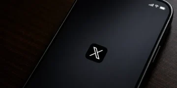 Screenshot of the X mobile application splash screen displayed on a smartphone, showing the X logo centered on a dark startup screen.