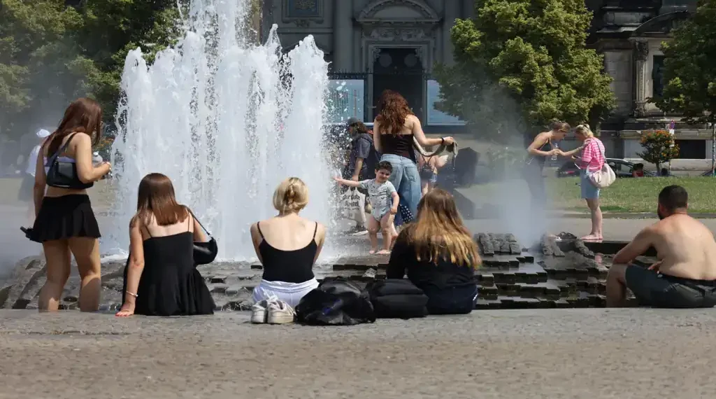 People cool off in the fountain at Berlin's Lustgarten during a summer heatwave in Germany.