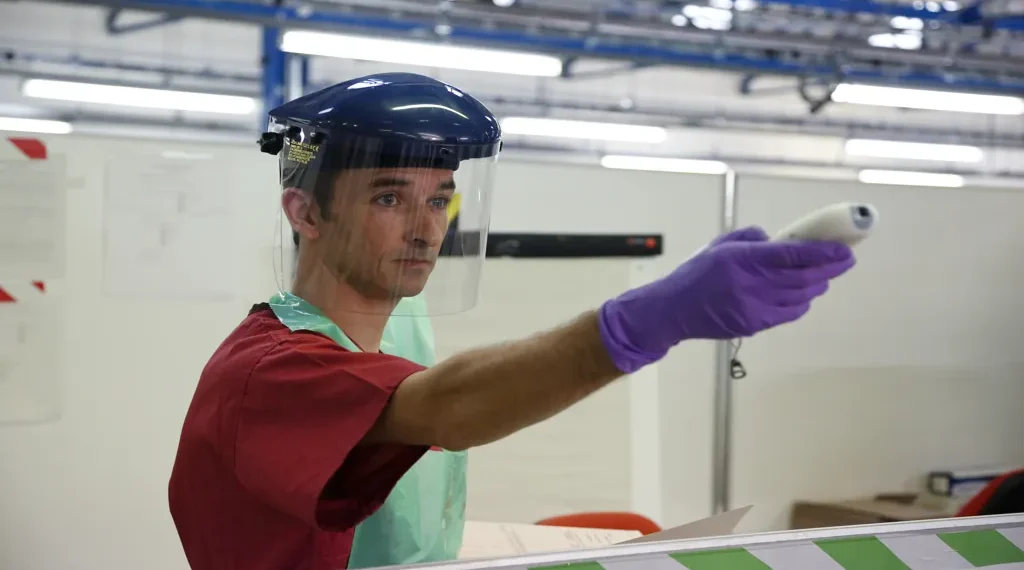 Army medic checks patients' temperatures during Ebola treatment training at a simulated treatment center near York, England.