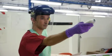 Army medic checks patients' temperatures during Ebola treatment training at a simulated treatment center near York, England.