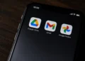 Close-up of a smartphone screen displaying the Google Drive, Gmail and Google Photos app icons against a dark background.