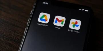 Close-up of a smartphone screen displaying the Google Drive, Gmail and Google Photos app icons against a dark background.