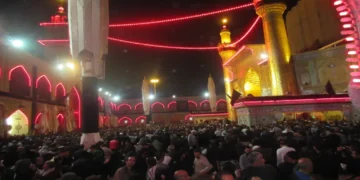 Pilgrims gather around the illuminated Imam Ali Shrine in Najaf, Iraq, during the annual Arbaeen pilgrimage, one of the world's largest religious gatherings.