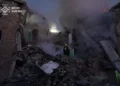 Firefighters from Ukraine's State Emergency Service work among the rubble of a severely damaged building as smoke rises following a Russian attack in Kyiv.