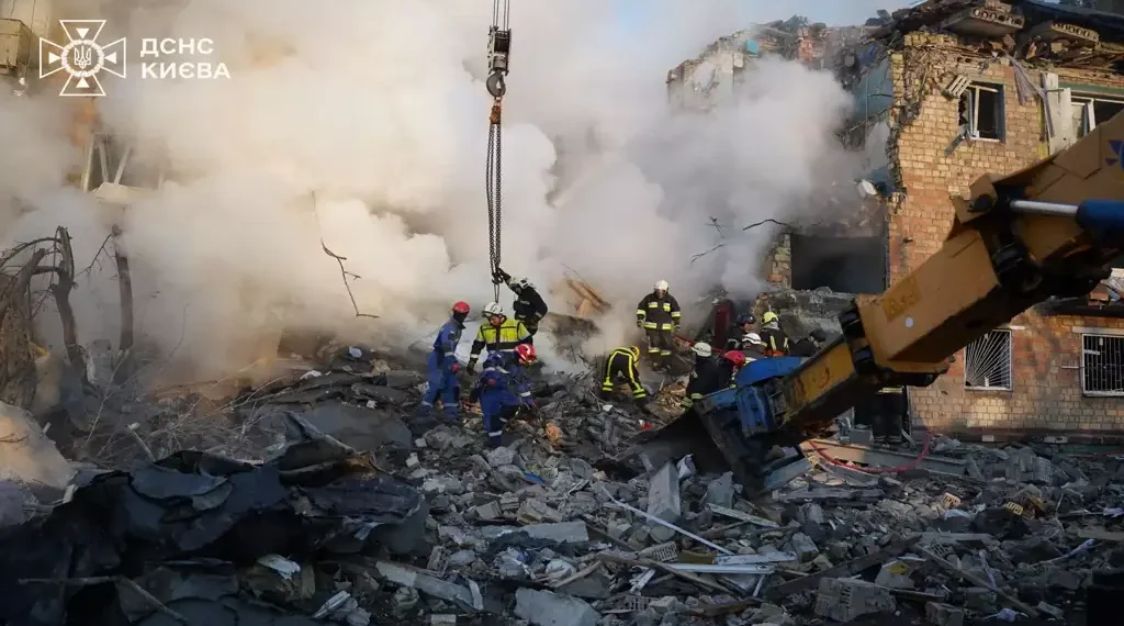 Emergency responders from Ukraine's State Emergency Service work at the scene of damage following a Russian attack in Kyiv.