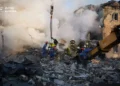 Emergency responders from Ukraine's State Emergency Service work at the scene of damage following a Russian attack in Kyiv.