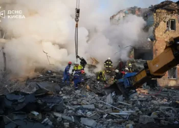 Emergency responders from Ukraine's State Emergency Service work at the scene of damage following a Russian attack in Kyiv.