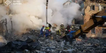 Emergency responders from Ukraine's State Emergency Service work at the scene of damage following a Russian attack in Kyiv.