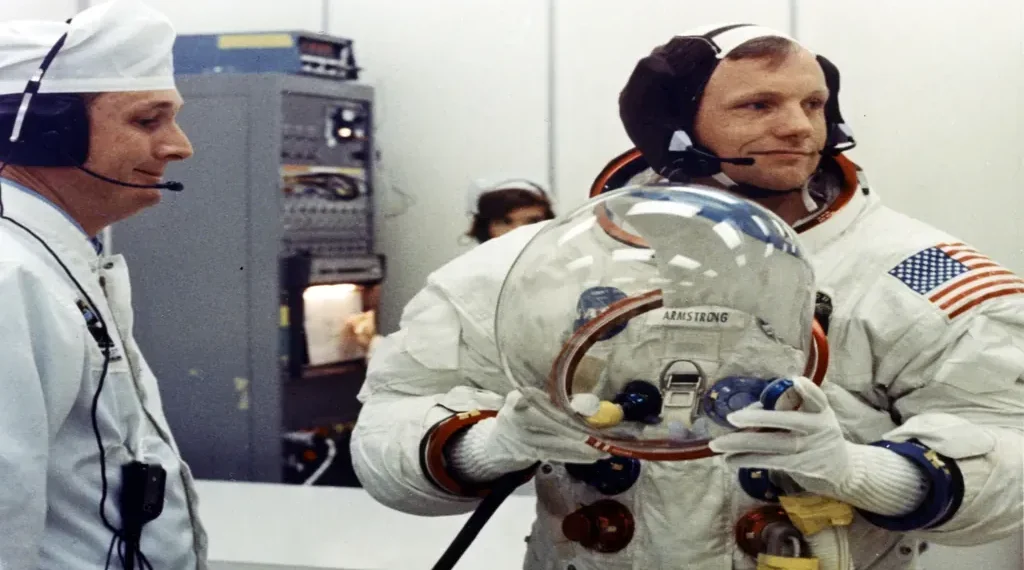 Apollo 11 Commander Neil Armstrong prepares to put on his space helmet with assistance from a technician before the historic Moon mission launch.