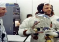 Apollo 11 Commander Neil Armstrong prepares to put on his space helmet with assistance from a technician before the historic Moon mission launch.