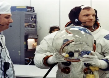 Apollo 11 Commander Neil Armstrong prepares to put on his space helmet with assistance from a technician before the historic Moon mission launch.