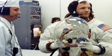 Apollo 11 Commander Neil Armstrong prepares to put on his space helmet with assistance from a technician before the historic Moon mission launch.