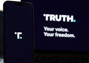Truth Social branding displayed on a smartphone beside a laptop showing the platform's desktop interface.