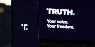Truth Social branding displayed on a smartphone beside a laptop showing the platform's desktop interface.