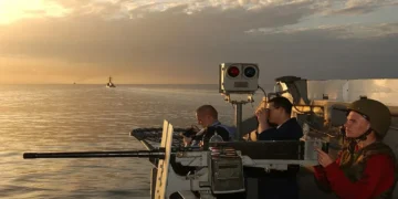 U.S. Navy sailor mans a .50-caliber machine gun aboard USS Kitty Hawk while transiting the Strait of Hormuz toward the Arabian Gulf.