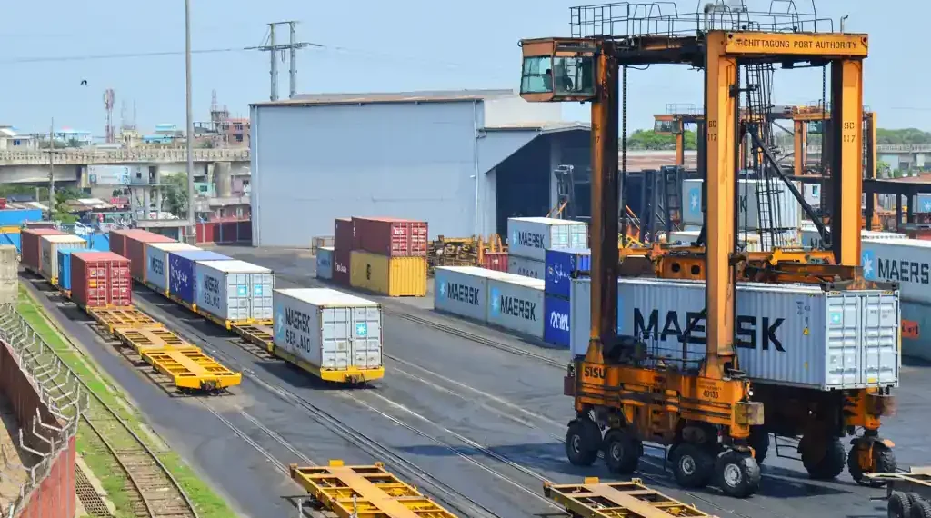 Straddle carrier moves a shipping container at Chattogram Port in Bangladesh during cargo handling operations.