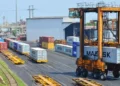 Straddle carrier moves a shipping container at Chattogram Port in Bangladesh during cargo handling operations.