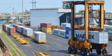 Straddle carrier moves a shipping container at Chattogram Port in Bangladesh during cargo handling operations.
