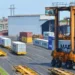 Straddle carrier moves a shipping container at Chattogram Port in Bangladesh during cargo handling operations.