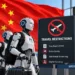 AI humanoid robots with luggage stand beside travel restriction signage at an airport against a Chinese flag backdrop.