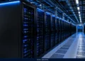 Data center interior showing rows of server racks with illuminated equipment, overhead infrastructure and a cooled technical floor.