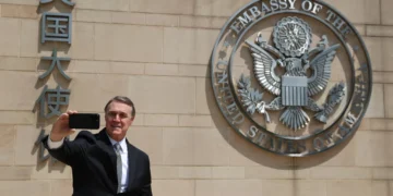 U.S. Ambassador to China David Perdue takes a selfie before the Great Seal at the U.S. Embassy in Beijing on May 15, 2025.