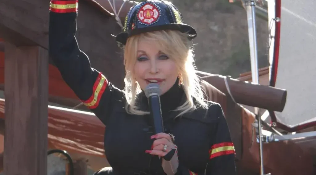 Dolly Parton in a firefighter outfit holding a microphone at Dollywood during a new attractions presentation on March 23, 2014.