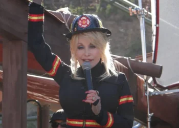 Dolly Parton in a firefighter outfit holding a microphone at Dollywood during a new attractions presentation on March 23, 2014.
