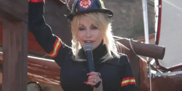 Dolly Parton in a firefighter outfit holding a microphone at Dollywood during a new attractions presentation on March 23, 2014.