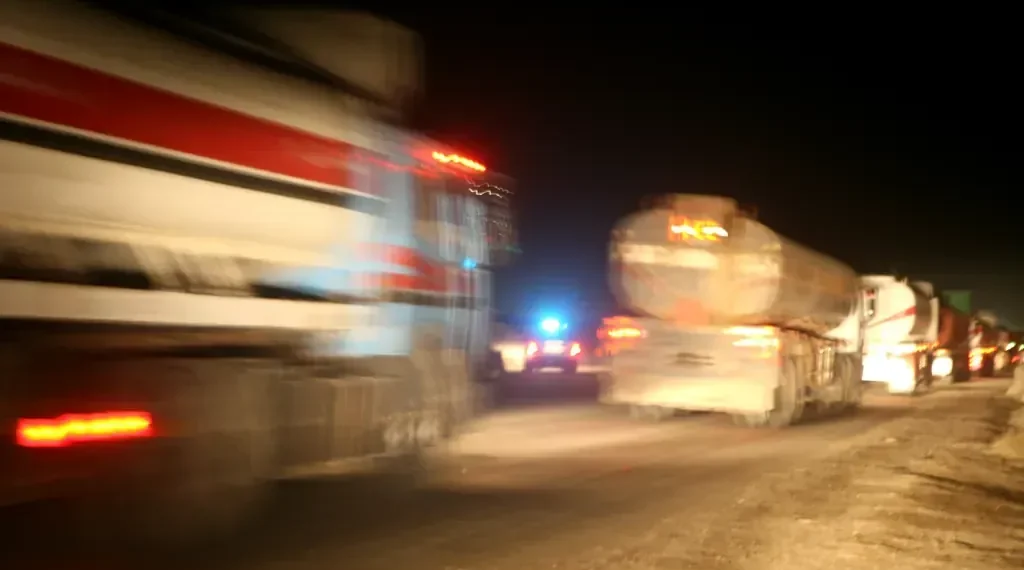 Iraqi fuel trucks convoy out of Camp Taji as Marines prepare vehicles for a mission to the Baiji Oil Refinery in Iraq.