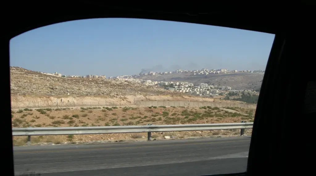 Two Israeli settlements are visible on hills in the West Bank, viewed from a Palestinian road during a 2008 journey.