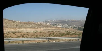 Two Israeli settlements are visible on hills in the West Bank, viewed from a Palestinian road during a 2008 journey.